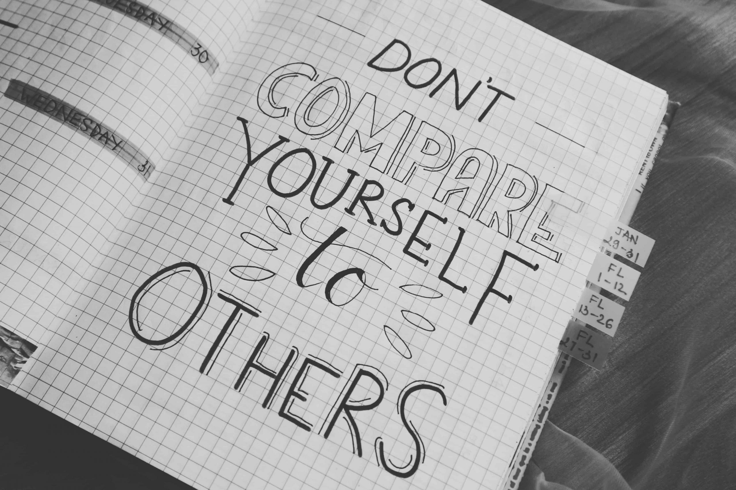 "Don't compare yourself to others" quote written on graph paper