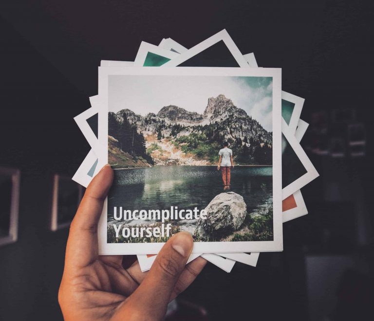 Uncomplicate Yourself quote on a polaroid picture of a person in nature