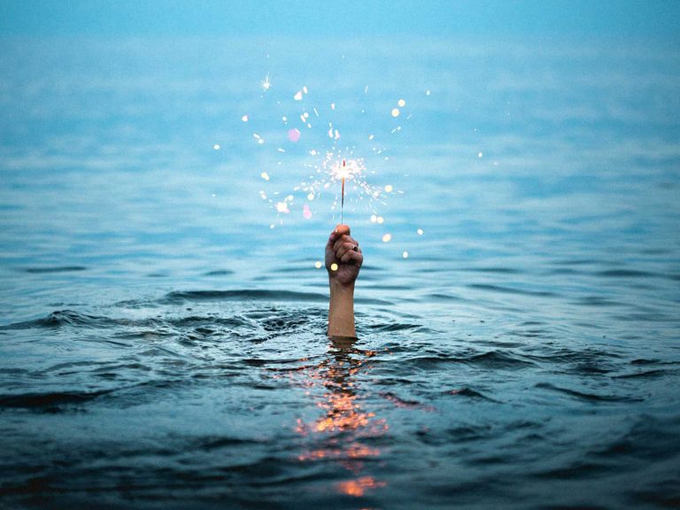 Hand holding light out of water