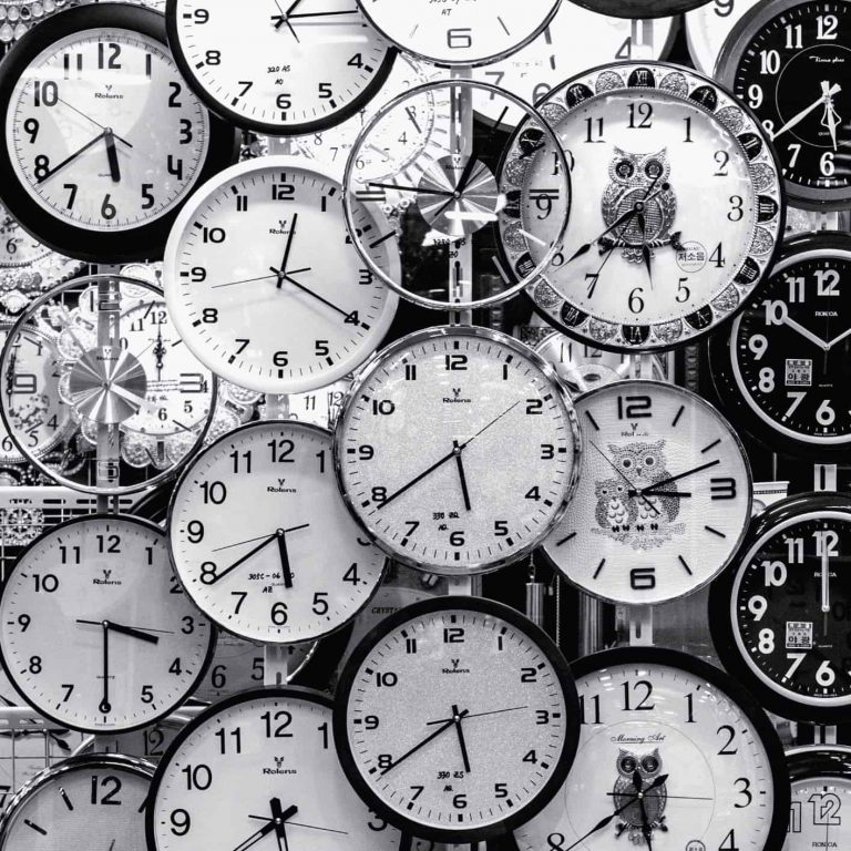 A wall filled with different types of clocks