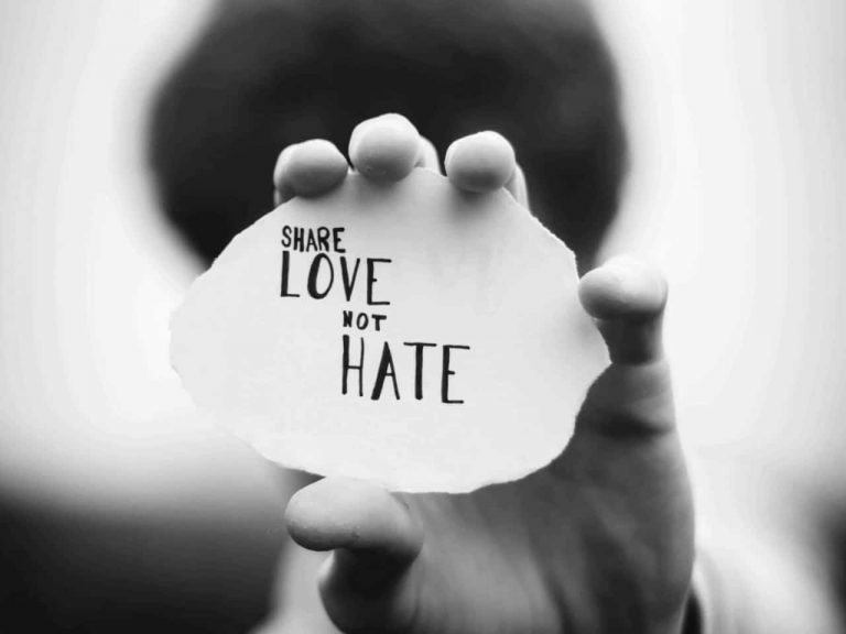 Person holding a sign that says "Share love not hate"