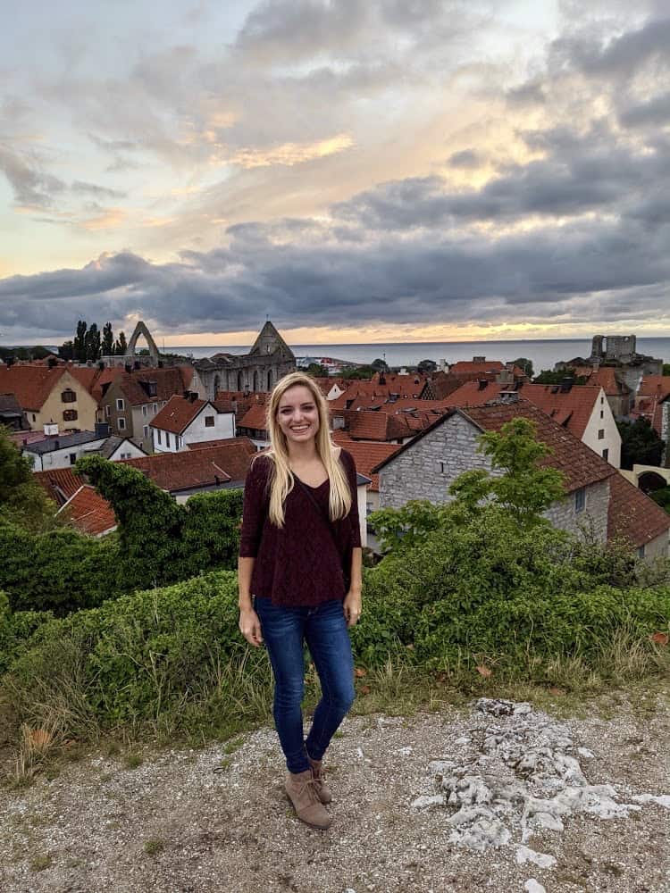 Kee standing on a hill overlooking the city and sea below