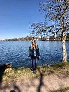 Kee standing in front of the lake with the city of Vadstena behind
