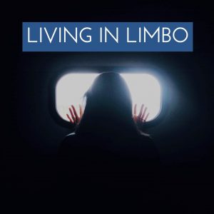 A person in the dark looking through a window into the light