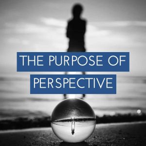 black and white picture of person with reflection in glass ball