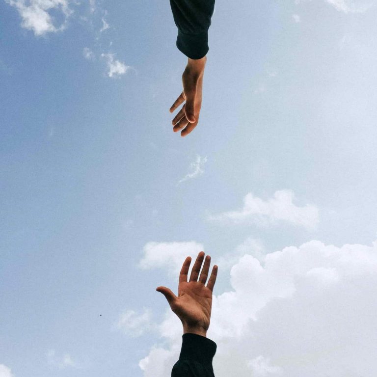 Two identical hands reaching vertically for the other