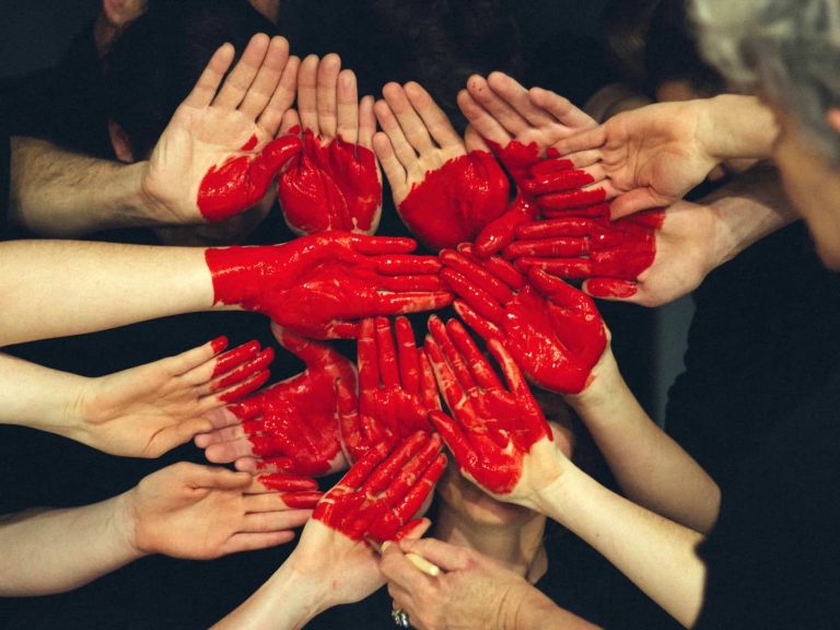 A group of people with their hands painted to look like a heart