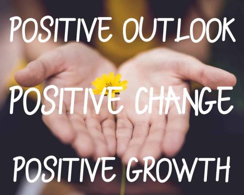 Picture of a yellow flower in open hands with the words "Positive Outlook, Positive Change, Positive Growth Mantra" over it